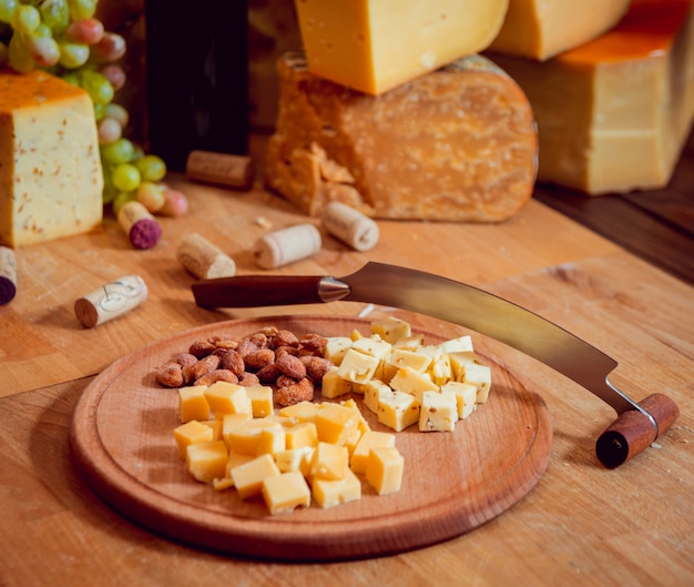 Cheese and wine on a dark table.