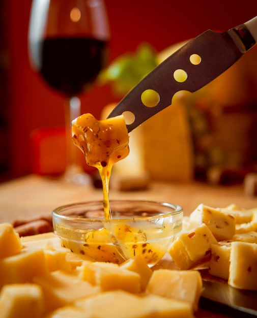 Cheese and wine on a dark table.