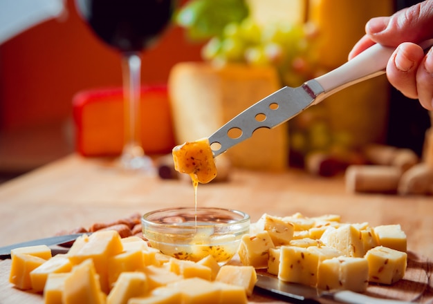 Cheese and wine on a dark table.