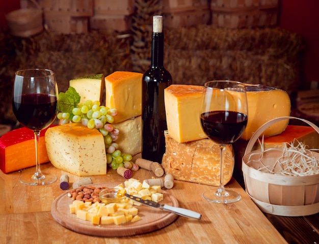 Cheese and wine on a dark table.