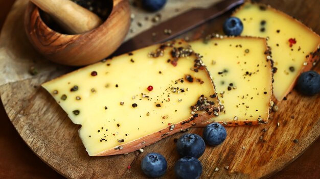Cheese with black pepper on a wooden board