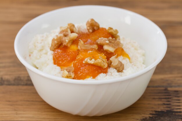 Cheese with pumpkin jam and nuts in white bowl