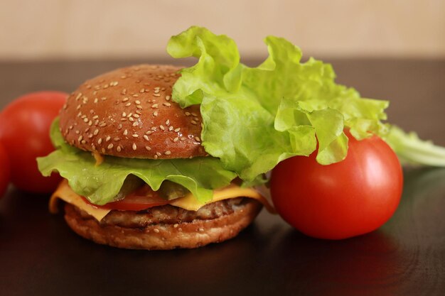 Cheeseburger close-up Zelfgemaakte hamburger en tomaten in de buurt Fast food