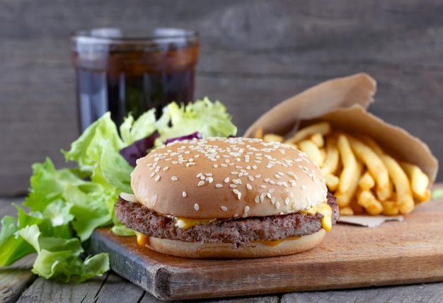 Cheeseburger and french fries in a bag and a glass of cola