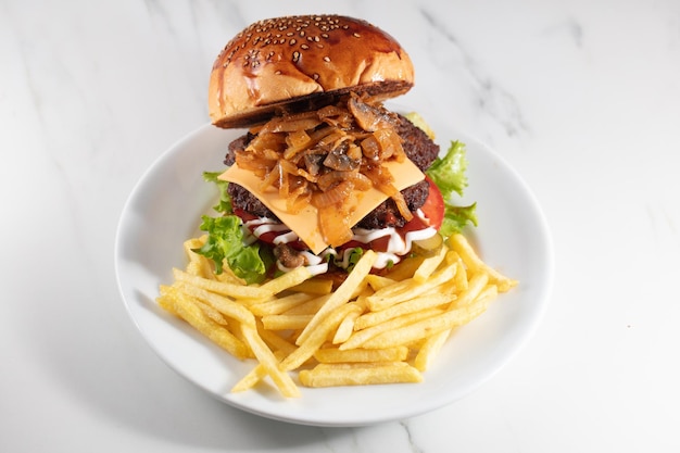 Cheeseburger and fries on plate served at restaurant