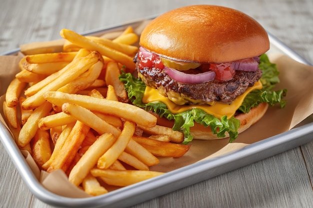 Cheeseburger and fries served on tray