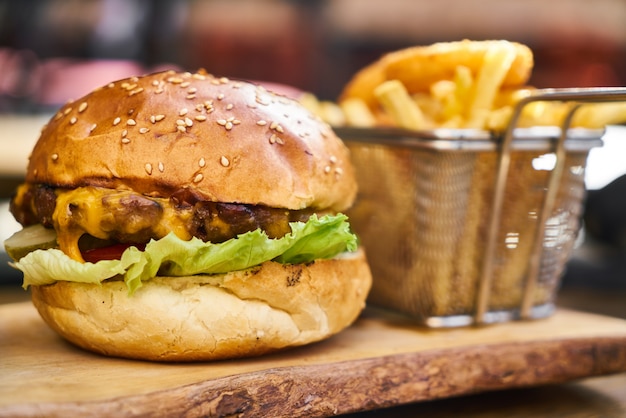 Cheeseburger met frietjes op de houten tafel