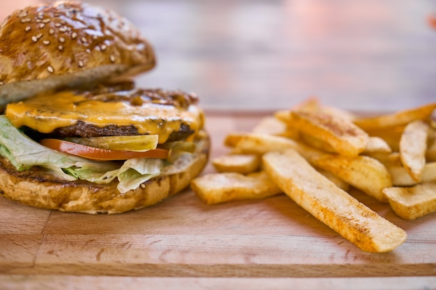 Cheeseburger met frietjes op de houten tafel