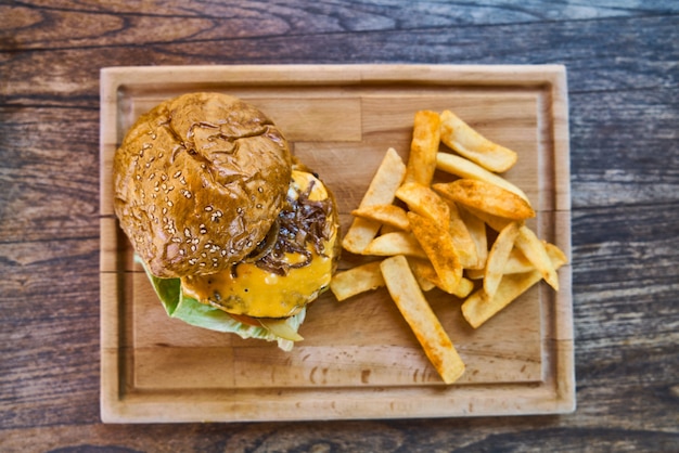 Cheeseburger with french fries on the wooden table