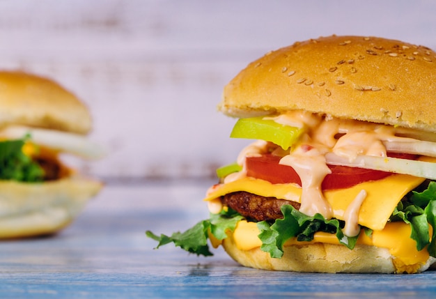 Cheeseburger with melted cheese on a white table.