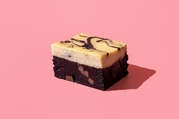 Cheesecake brownie minimalist on a pink background Slice of homemade brownie