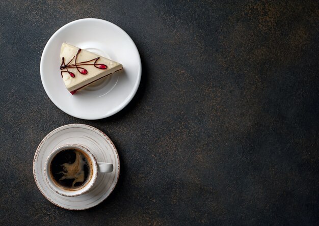 Cheesecake - cake op een witte plaat en koffie op stenen achtergrond met kopie ruimte voor uw tekst