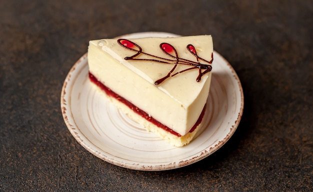 Cheesecake - cake on a white plate on a stone background with copy space for your text