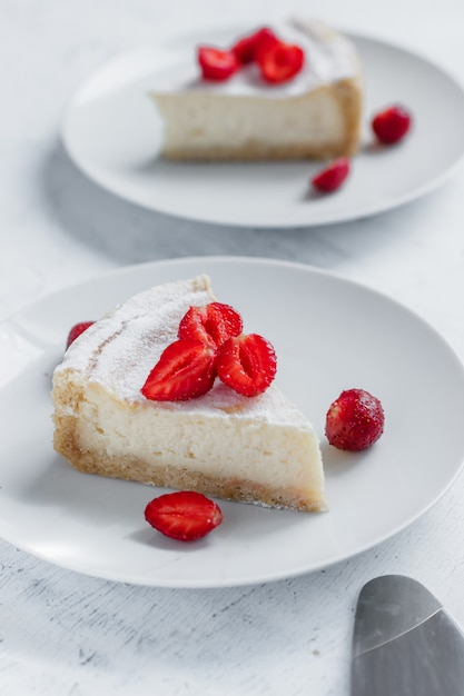 Cheesecake decorated with strawberries on a white plate