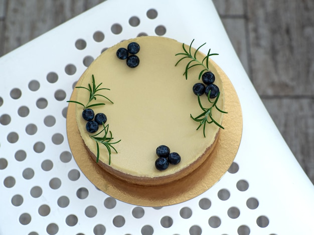 Cheesecake gedecoreerd met bosbessen en takjes rozemarijn