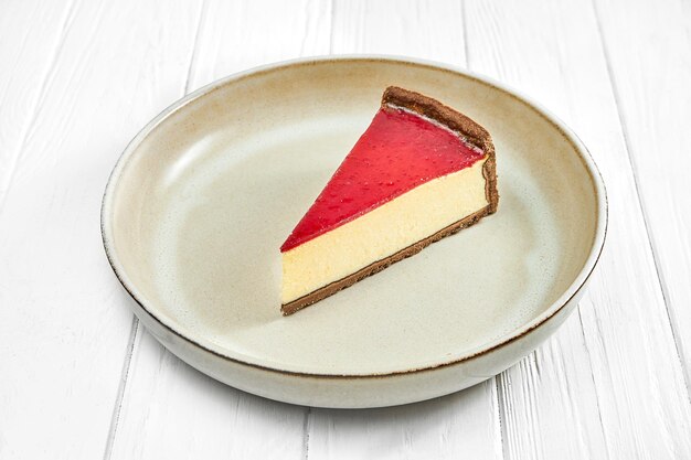 Foto cheesecake met aardbeien in een bord op een witte houten achtergrond