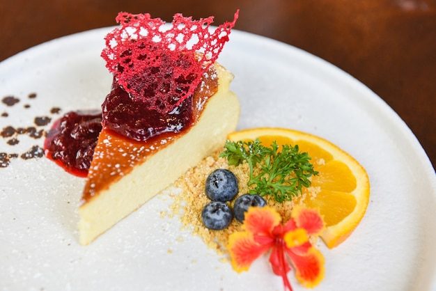 Cheesecake slice with raspberry sauce on white plate