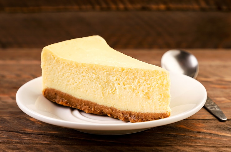 Foto cheesecake stuk op een plaat close-up op een houten achtergrond