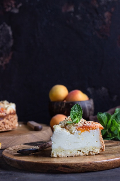 Cheesecake with apricot and crumble, fresh apricots and mint. 