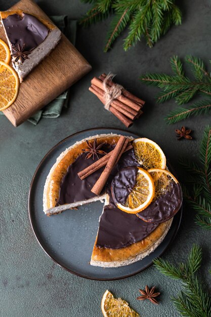 乾燥オレンジシナモンとアニスのチョコレートで飾られたスライスとチーズケーキ