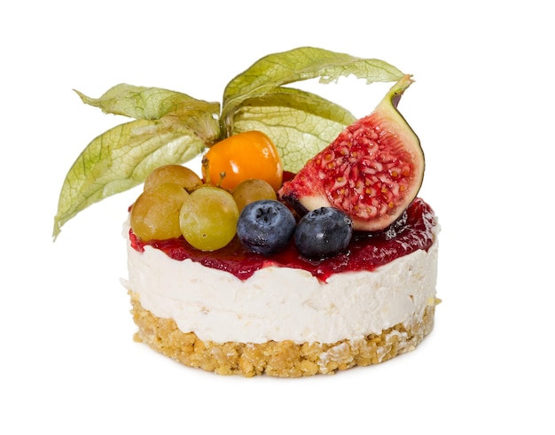 Cheesecake with figs grapes blueberries and physalis isolated on white background