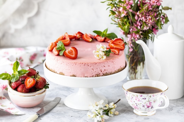 Cheesecake with fresh strawberries on a white table. Selective focus