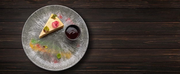 Cheesecake with jam on a plate on a wooden background