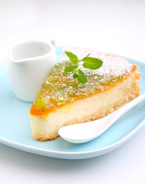 Cheesecake with kiwi on a plate decorated with mint