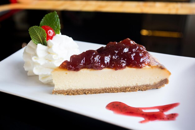 Cheesecake with red fruit sauce and fresh fruit such as raspberries, blueberries or strawberries.