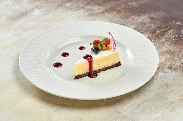 Cheesecake with sauce in a white plate on a white plate