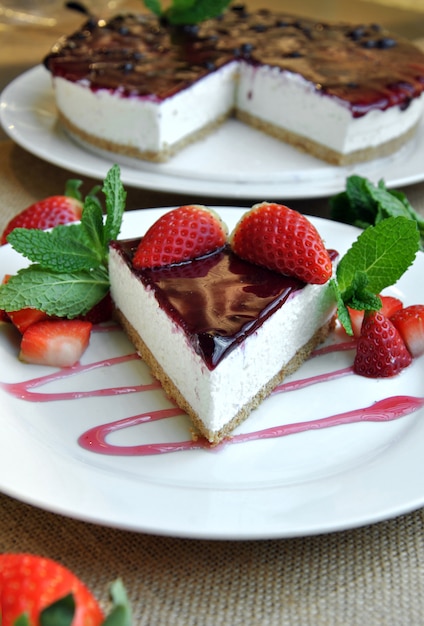 Cheesecake with strawberries and decorated with mint leaves