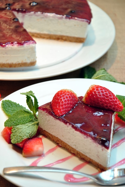 Cheesecake with strawberries and decorated with mint leaves