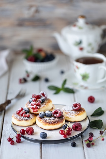 Cheesecakes of cottage cheese with berries with a branch of berries Irga.