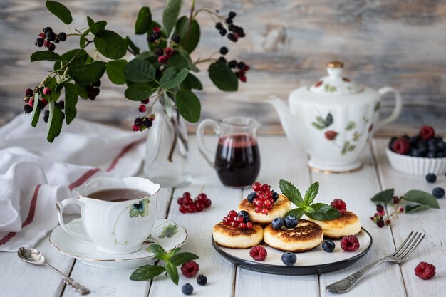 Cheesecakes of cottage cheese with berries with a branch of berries Irga.