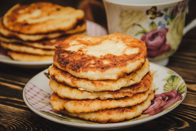 チーズケーキとカップの木製のテーブル