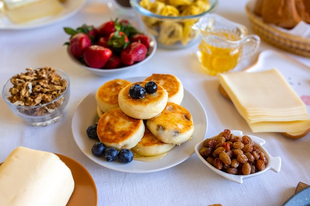 Cheesecakes op een witte tafel Cheesecakes met bessen en honing Prachtig ontbijt Voedseldag