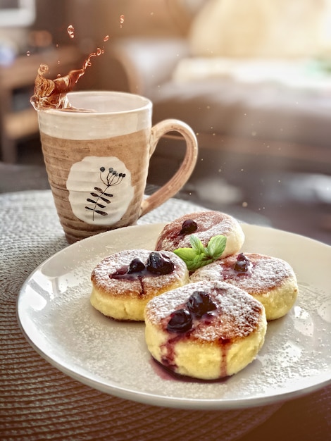 Cheesecakes on a white plate with a cup of tea