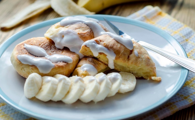 Cheesecakes with banana and sour cream on a plate closeup