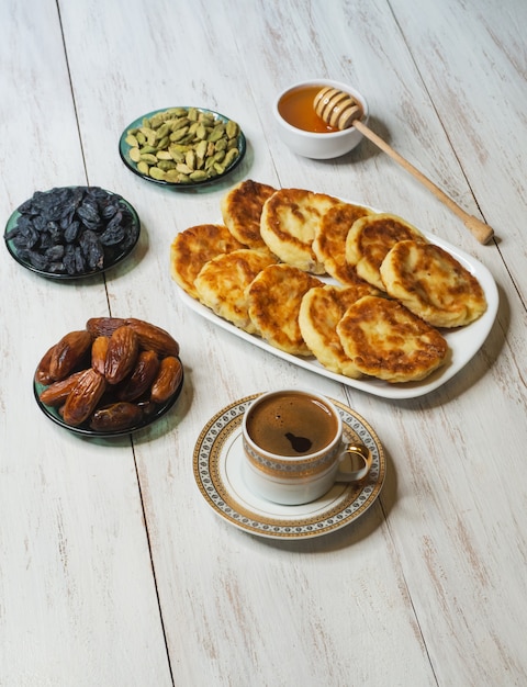 Cheesecakes with honey, dates and coffee on the table.