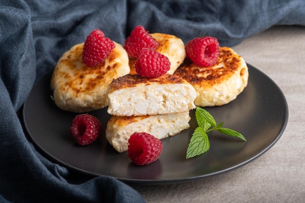 Cheesecakes with mint, raspberries, honey. Ukrainian, Russian cuisine breakfast meal. Homemade food.