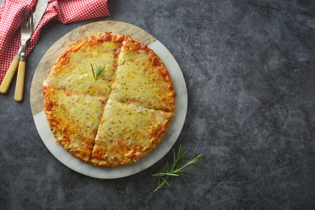 Cheeses delicious homemade pizza with thick crust on dark table