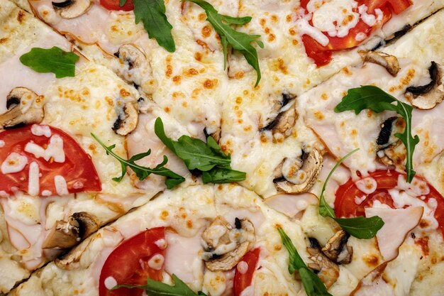 Cheesy smoked meat pizza with tomatoes arugula and mushrooms closeup