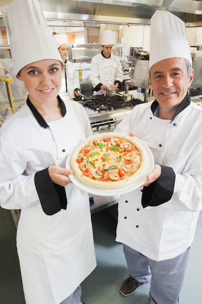 Chef&#039;s presenting a pizza