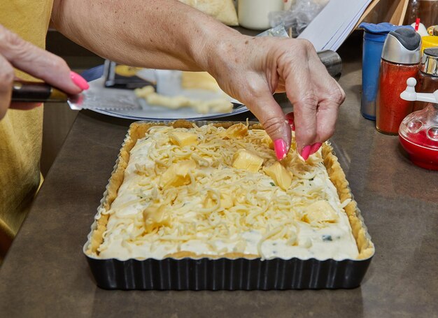 Chef adds butter to squareshaped cheese pie