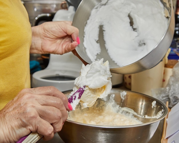 Chef adds whipped egg whites to the pie dough in the bowl