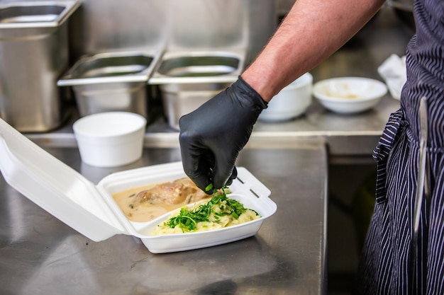 Chef bereidt afhaalmaaltijden in restaurant of pub maaltijdbezorging concept thuisbezorging online bestelling
