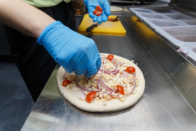 Chef bereidt pizza op metalen tafel close-up