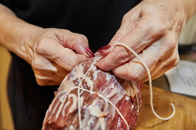 Chef bindt het rundvlees vast met touw en bereidt het voor op bakken in de oven