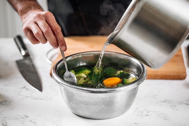 Chef blanching broccoli in a hot water