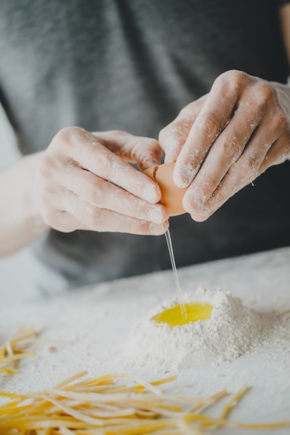 Photo chef breaking egg for cooking dough